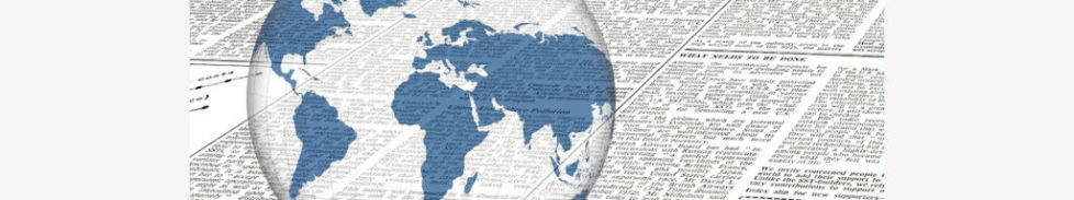 Mondo con continenti colorati di blu e sullo sfondo pagina di giornale